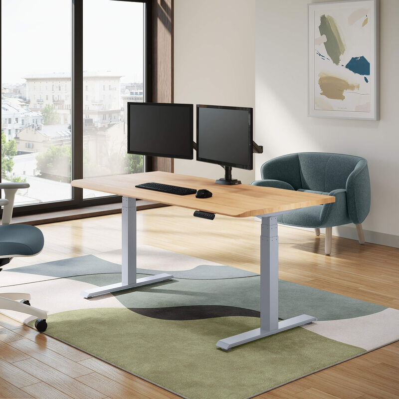 solid wood electric standing desk with a white oak top with silver legs in an open home office in lowered position image number null