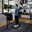 A modern, stylish home office setup featuring a curved desk with triple monitors, ergonomic chair, desktop PC, and a cozy workstation with vintage cameras and a turntable in the background.