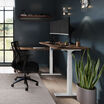 walnut and white standing desk in office in raised position