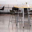 four tall wave side chairs around a tall round table in a lounge area