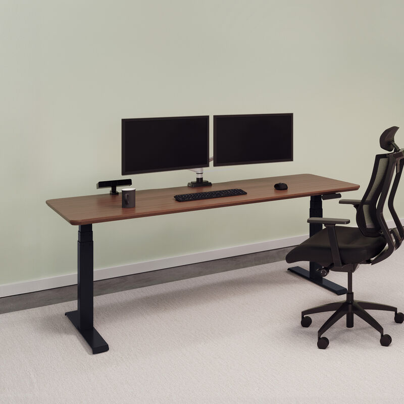 Electric standing desk 72x30 in walnut finish with black legs lowered in office image number null
