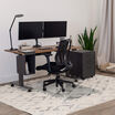 glass chair mat setup under a chair and electric standing desk on a high pile rug