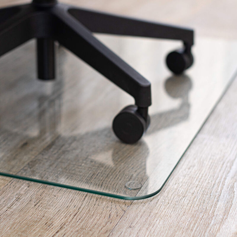 close up of the tapered edge of glass chair mat with a rolling desk chair  image number null