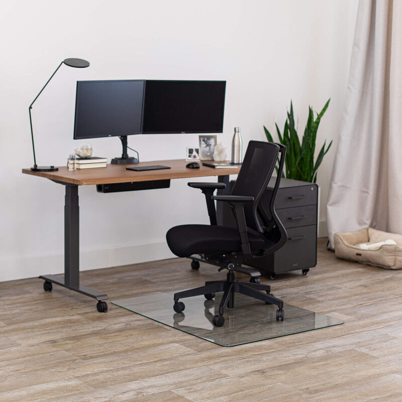 glass chair mat setup under a chair and electric standing desk on wood floor image number null