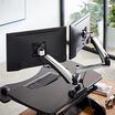 dual-monitor arm attached to varidesk converter in office