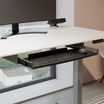 keyboard trey attached to desk with keyboard and power hub