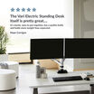 electric standing desk in an office with a customer review reading the vari electric standing desk itself is pretty great it's sturdy easy to put together has a qulity build and holds more weight than expected
