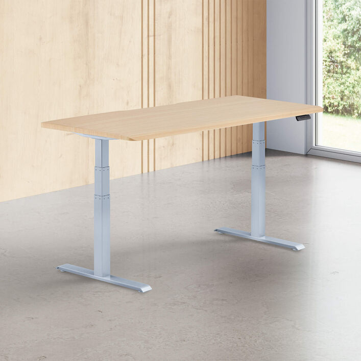 light wood finish standing desk top with silver legs in a open office image number 0