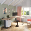 light wood finish l shape electric standing desk in an office workspace