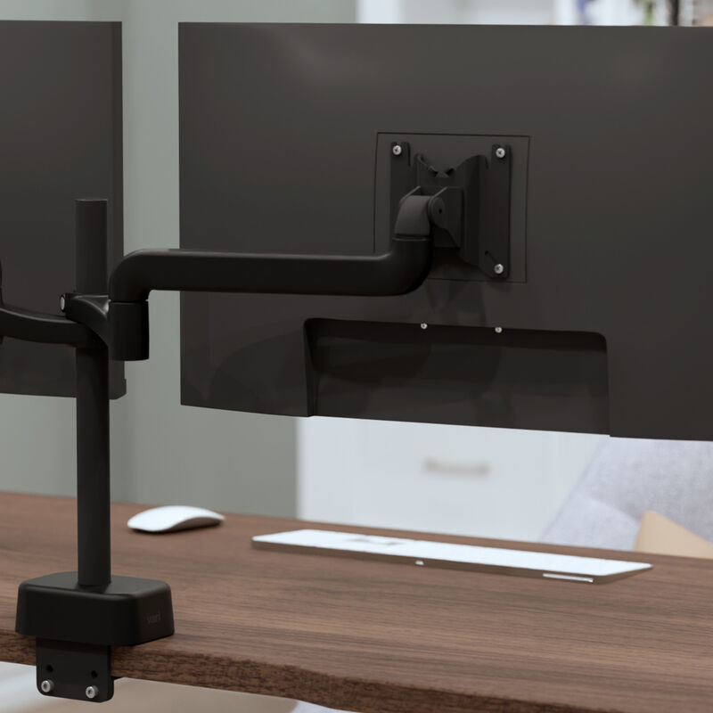 Close-up of a dual monitor arm's mounting plate attached to the back of a monitor, showing the pivot joint and VESA screws. image number null