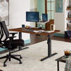 Electric Standing Desk 60x30 Dark Wood in lowered position at home