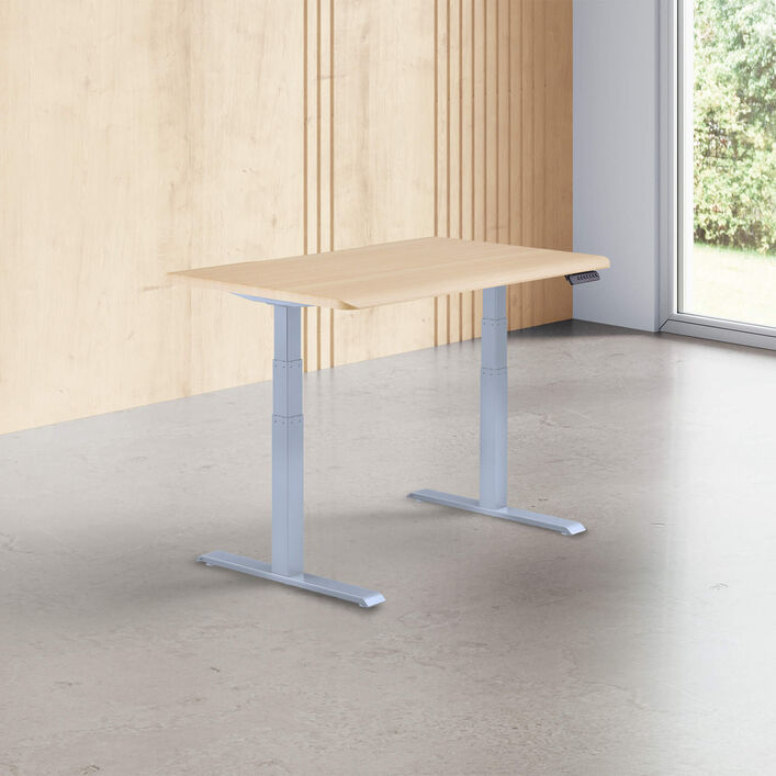 light wood finish standing desk top with silver legs in a open office image number 0