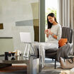 professional seated in living room with portable laptop stand on coffee table propping up laptop