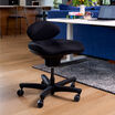 Tchair with a contoured seat and curved backrest placed on a wooden floor near a desk in a home office setting