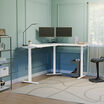 l shape electric standing desk with white desktop and white legs in a raised position 