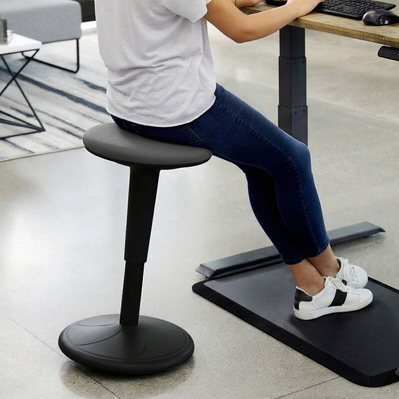 individual sitting on a balance stool while working at a desk image number null