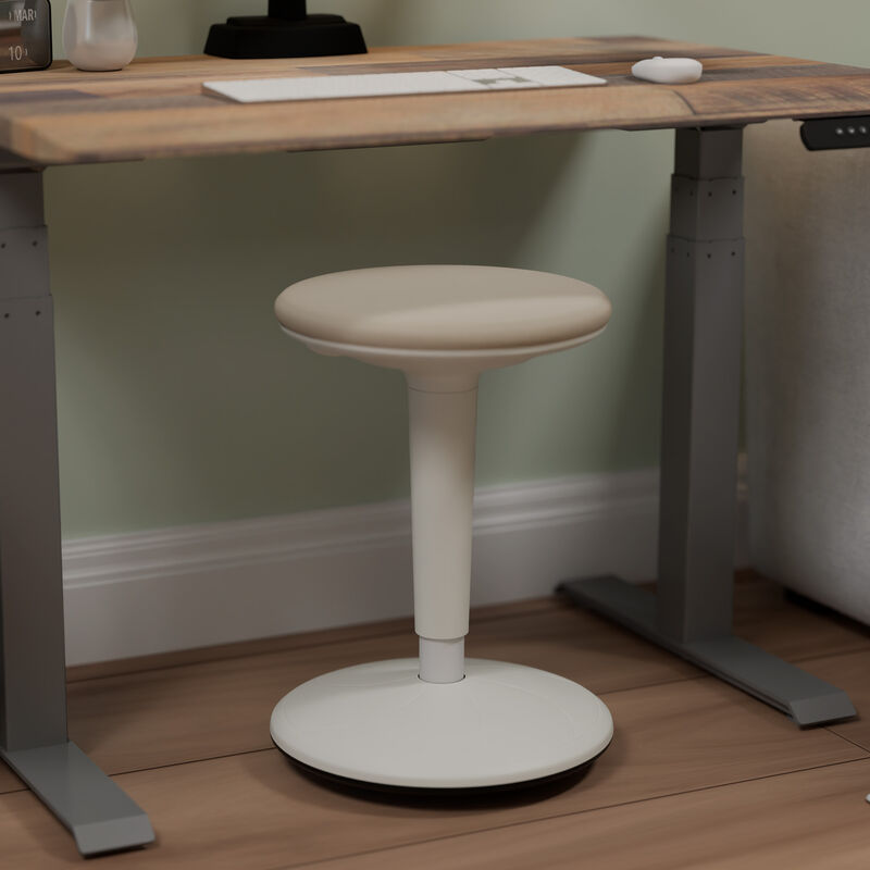 balance stool sitting in front of an electric standing desk in a home office in a lowered position image number null