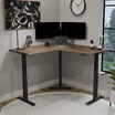 walnut finish l shape electric standing desk in an office workspace lowered