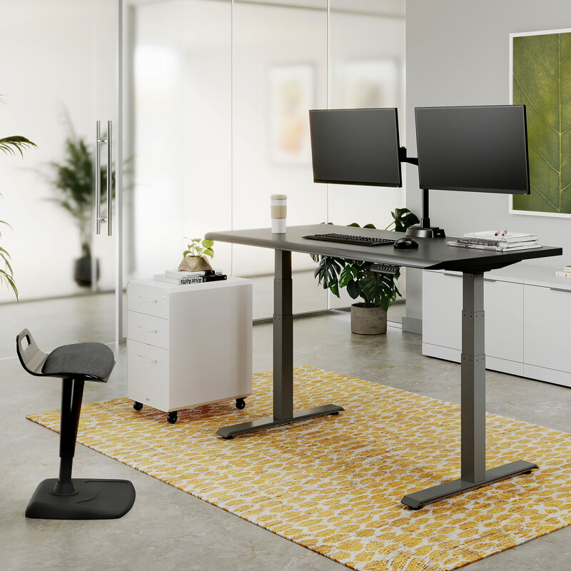 Posture perfect bundle setup in a workspace with an electric standing desk a dual monitor arm a file cabinet and active seat  image number null