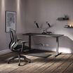 Curve Electric Standing Desk 60x30, Performance Task Chair, Dual-Monitor Arm, Standing Mat 34x20, Power Hub and Power Strip 8ft are shown with out monitor screens and additional decorations. 