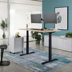 Electric Standing Desk 60x30 light wood in raised position at home
