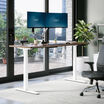 walnut finish standing desk top with silver legs in a open office