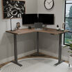 walnut finish l shape electric standing desk in an office workspace