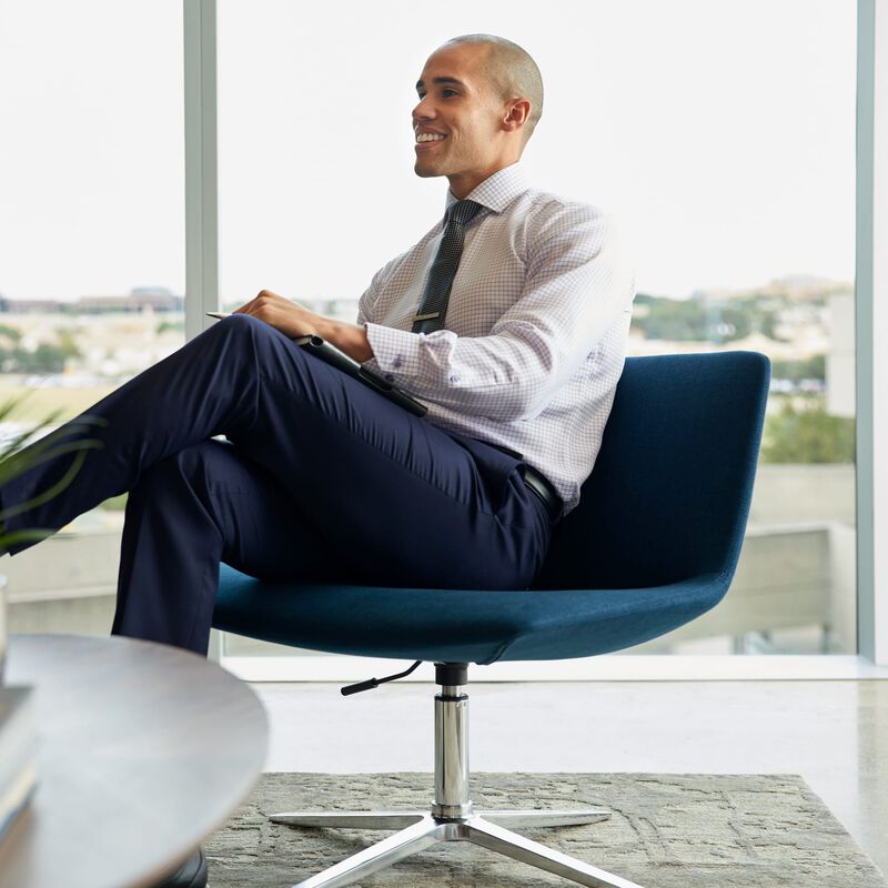 professional seated in navy lounge chair in office setting image number null