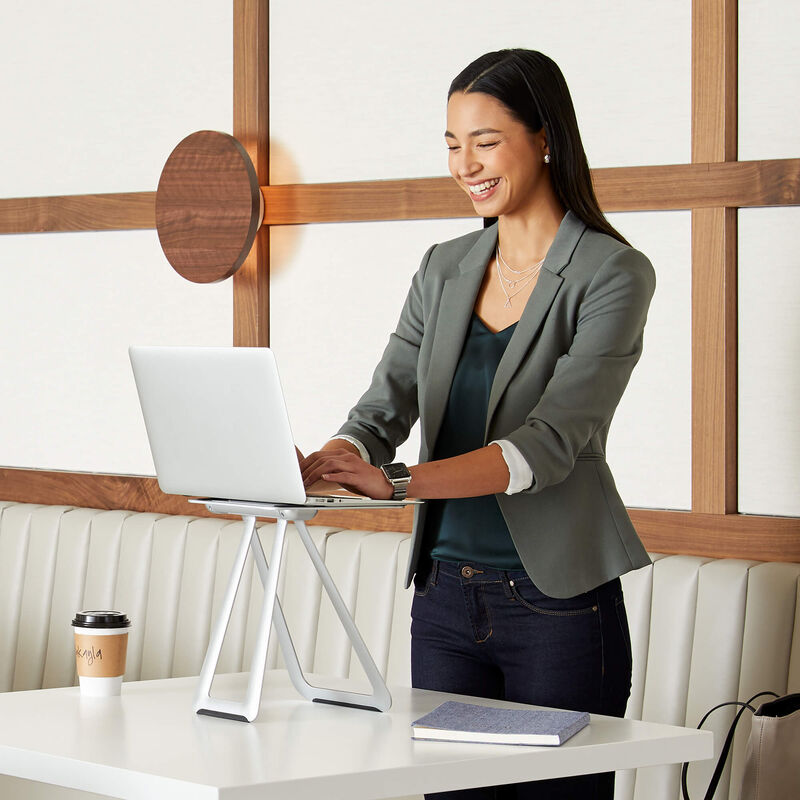 professional with laptop mounted on portable laptop stand in cafe  image number null