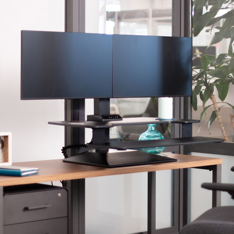 premier electric dual monitor setup with the monitor mount in the black finish on a table top workspace in office environment image number null