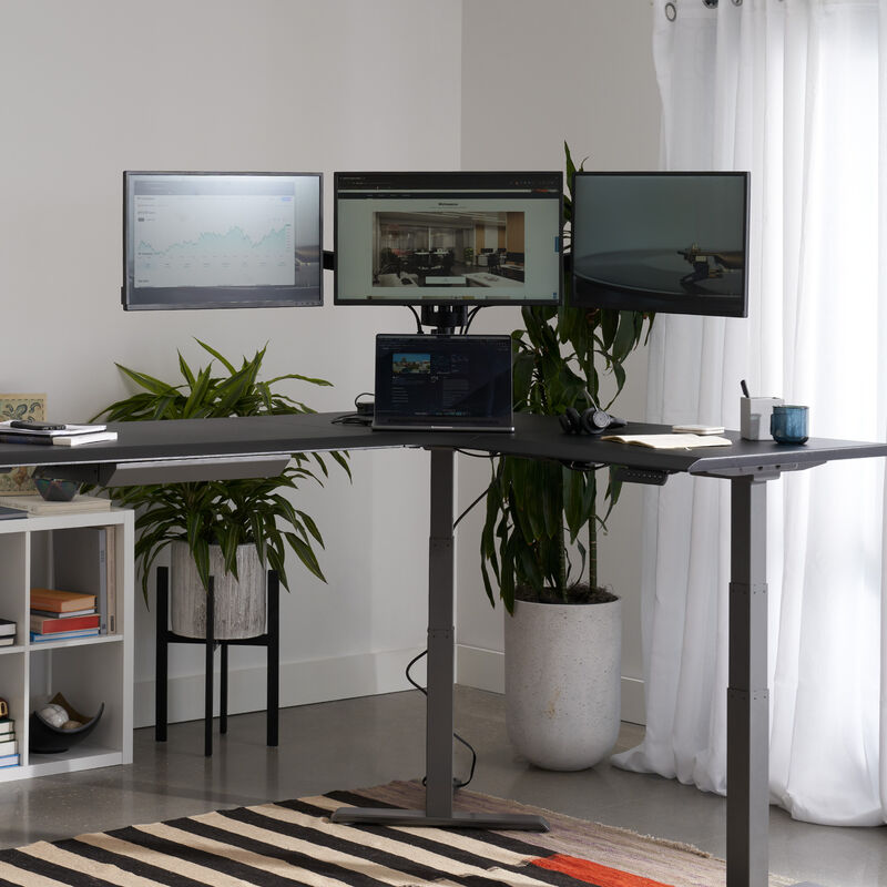 triple monitor arm setup on the vari l shape desk in the corner of a workspace image number null