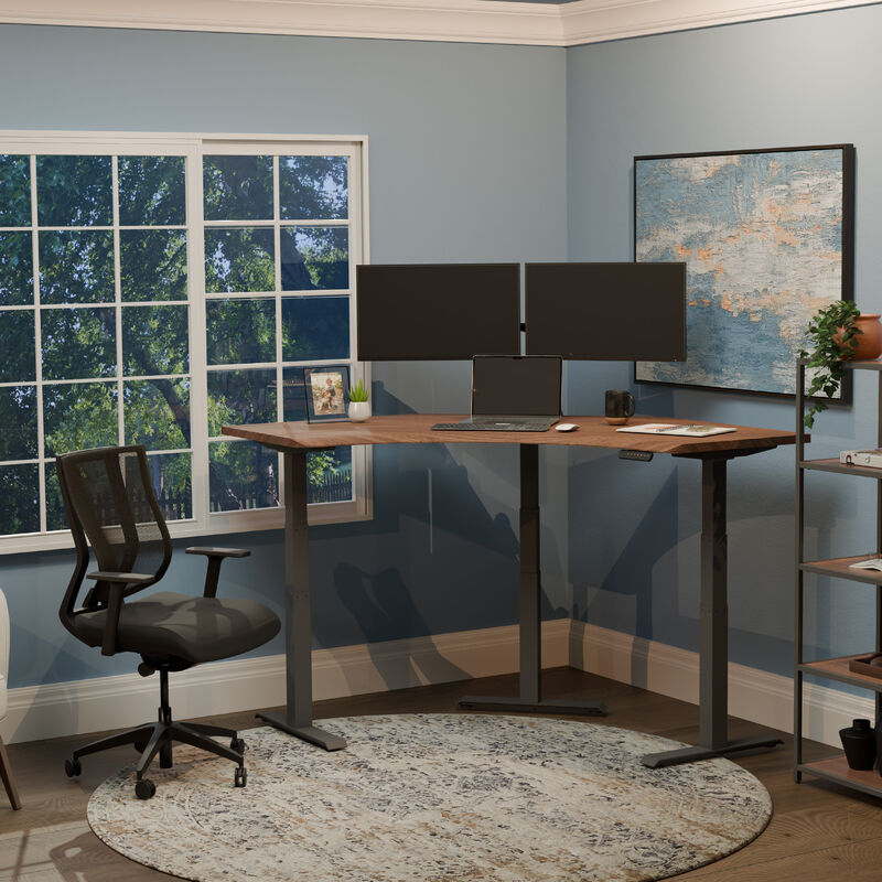 A clean and modern home office setup with a walnut command center standing desk, dual monitors, mesh ergonomic chair, and blue walls accented by large windows and abstract wall art. image number null