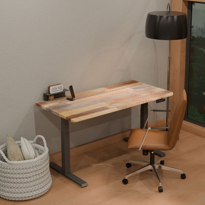 Reclaimed wood TechTrack ESD desk with a black frame in a home office corner, sitting, styled with a flip clock, phone stand, cognac leather office chair, floor lamp, and a woven basket with pillows. image number null