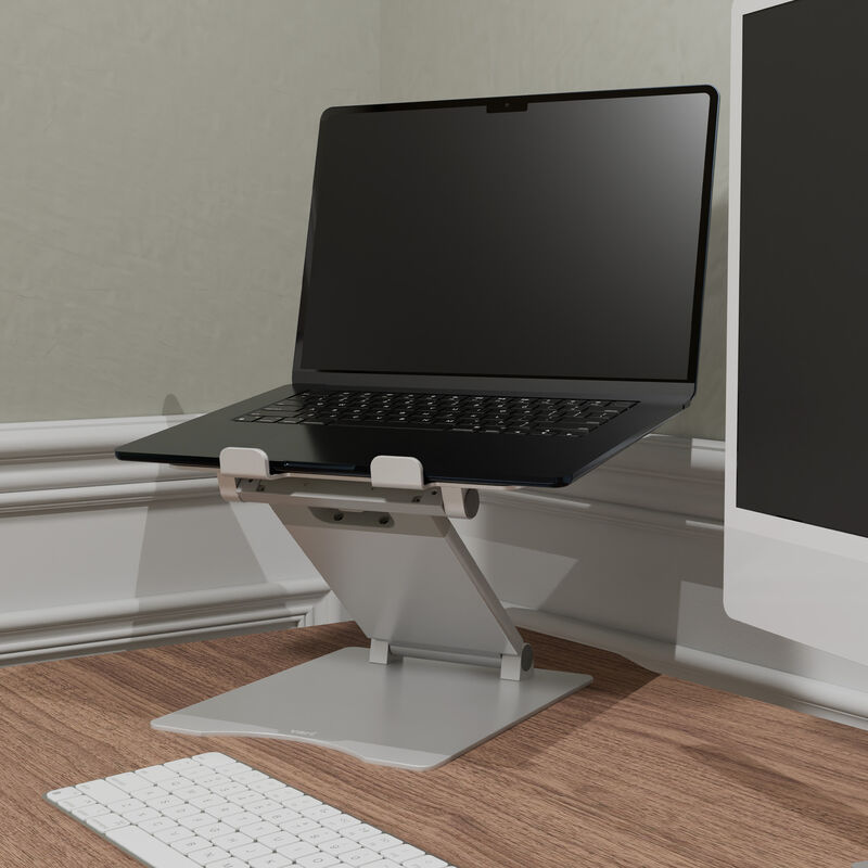 laptop on top of laptop stand sitting next to a monitor on a home office desk image number null