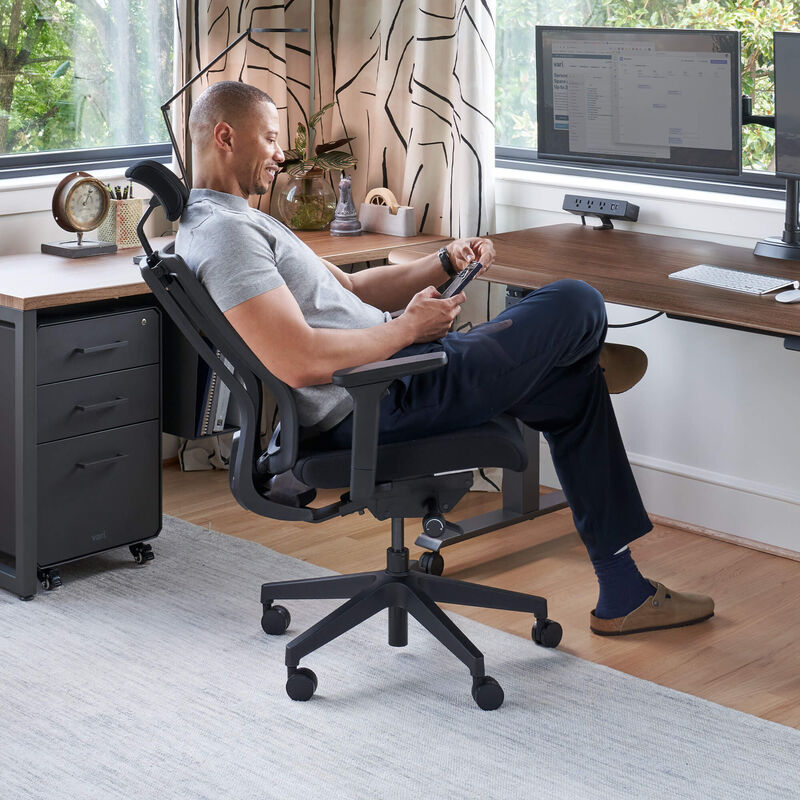 task chair with headrest in black finish used in a home office setting image number null