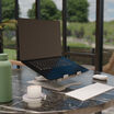 laptop stand in raised position with a laptop on top of it
