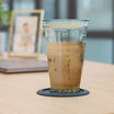 iced drink sitting on a coaster on a vari table top