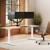 Solid Wood Electric Standing Desk with a white oak top and silver frame shown from a slightly different angle in the same sunlit home office, with a triple-monitor arm mounted above the desktop.