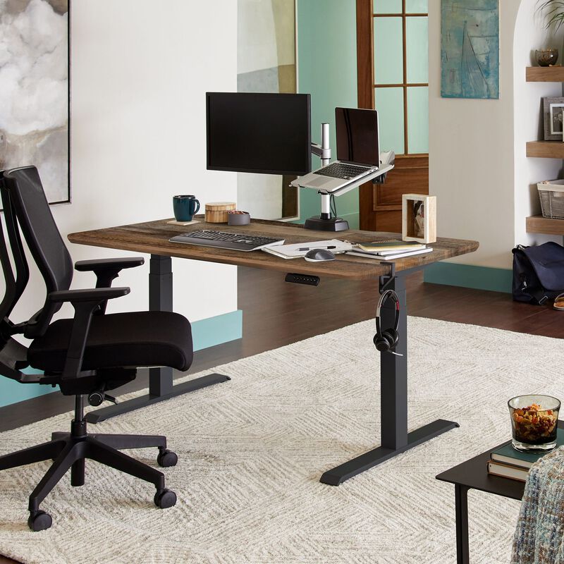 Electric Standing Desk 60x30 in reclaimed wood finish in lowered position in an home office setting. image number null
