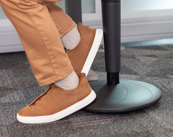 close up view of the base of the balance stool with a man resting his foot on the base