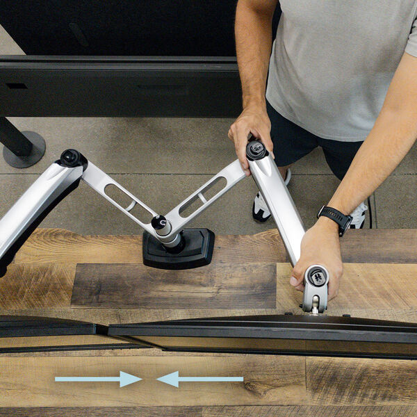adjusting arms to bring monitors together