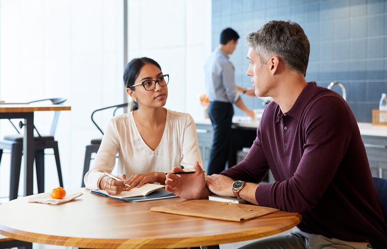 Professionals have casual meeting in breakroom at a round table