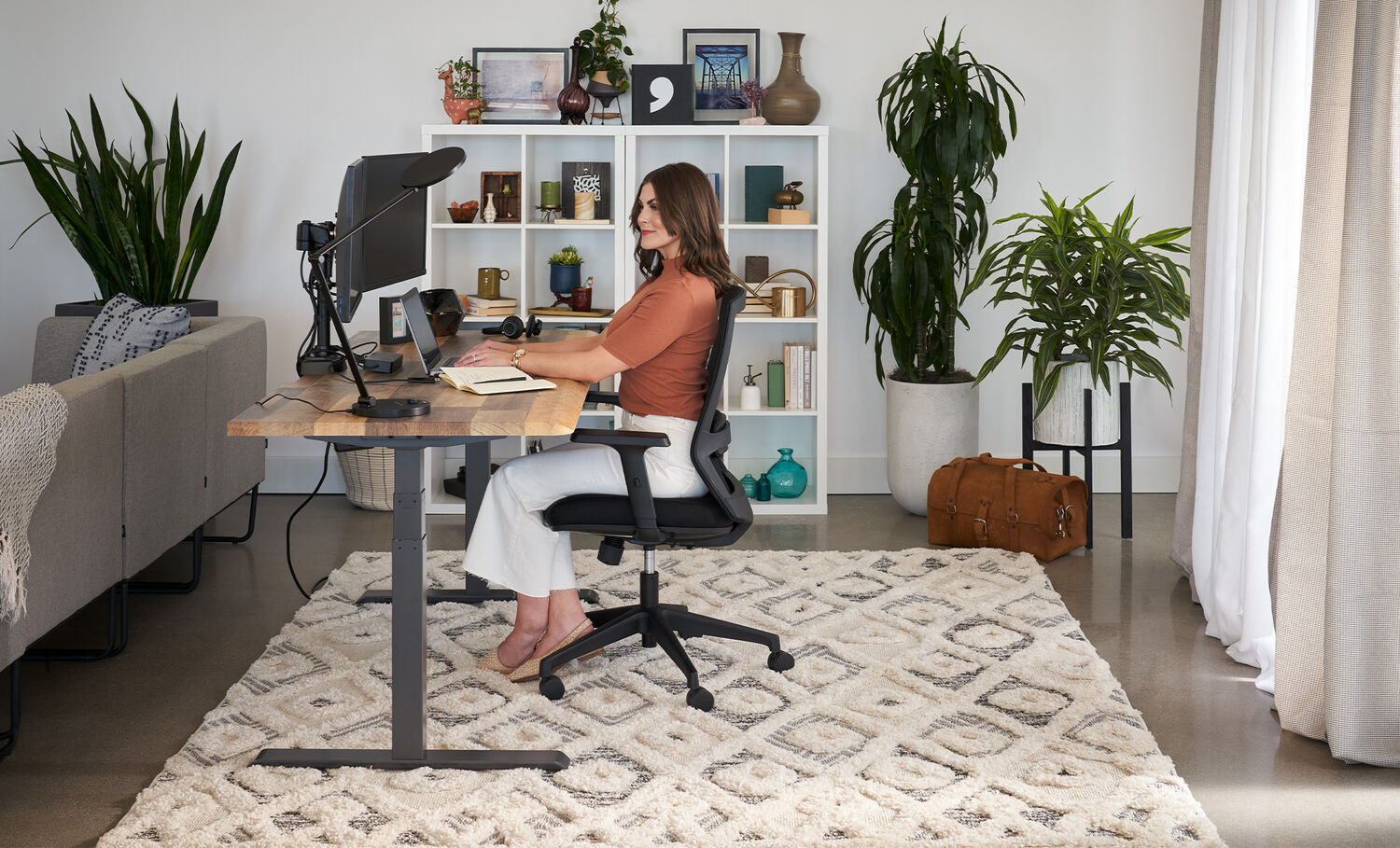 woman sitting in essential task chair with other products used to create flexible workspace