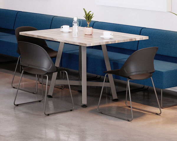 square table with three chairs and a couch seating option in a casual meeting area