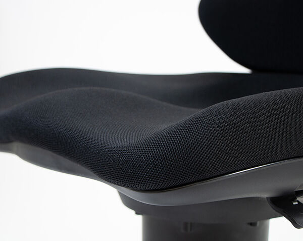 Close-up of black mesh seat cushion with a contoured wave-shaped design and visible backrest edge in the background.