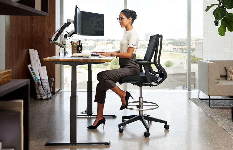 Professional sitting on Vari drafting chair in office
