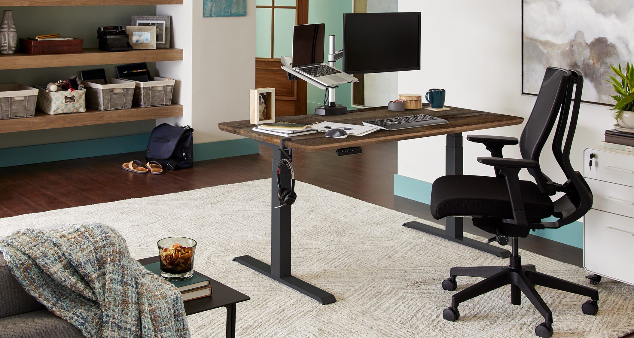 an electric standing desk paired with vari accessories creates a comfortable home workspace