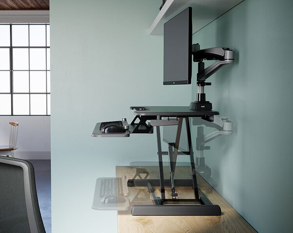 Side view of the Varidesk Essential Vertical Lift 30 in a raised position with a soft outline of the Varidesk Essential Vertical Lift 30 in the lowered position. 