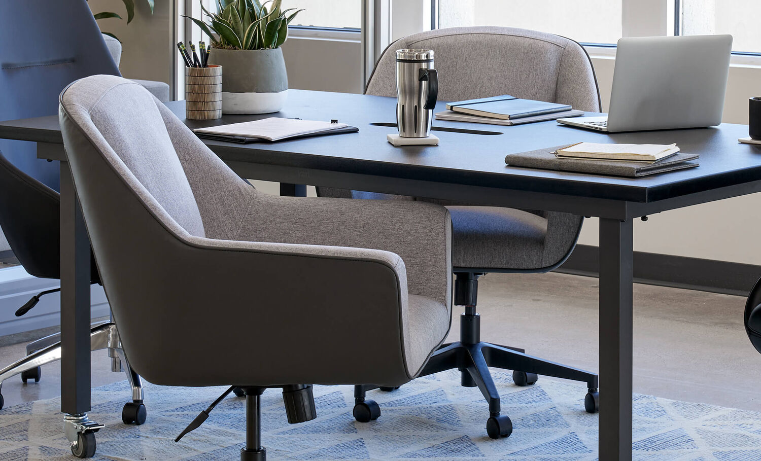 A closeup view of a conference room with the Vari upholstered conference chair with faux leather finish on the outer shell giving the chair a stylish two-tone look.