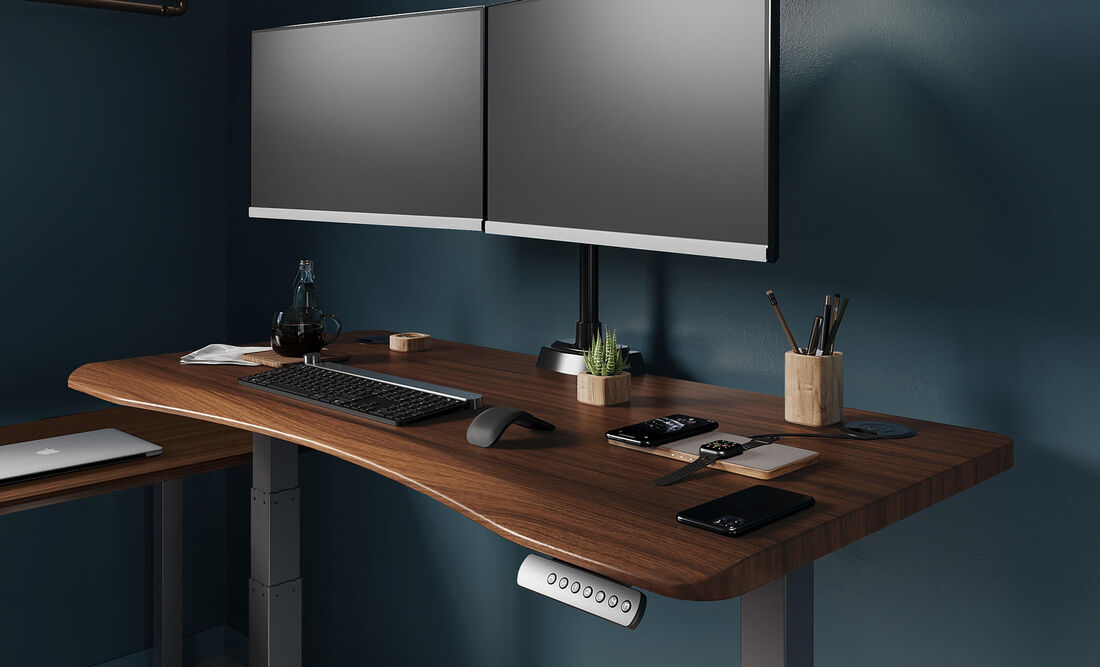 close up view of ergo electric standing desk with desk accessories and a monitors sitting on top of it